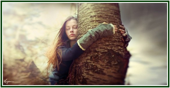 Mulher de olhos fechados a abraçar uma árvore, simbolizando a paz e o verdadeiro amor na teosofia.