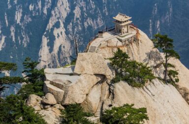 Pavilhão do Xadrez de Huashan no topo de uma montanha rochosa e isolada com pinheiros, simbolizando a paz perfeita no meio das dificuldades.