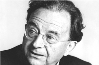 Retrato fotográfico em plano aproximado e a preto e branco do psicanalista Erich Fromm, focado de perfil parcial enquanto usa os seus óculos de armação fina, cuja perspetiva humanista ajuda a analisar a experiência do satori.