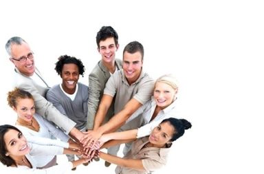 Grupo de pessoas unidas com as mãos ao centro, simbolizando a cooperação mútua e a verdadeira evolução espiritual.