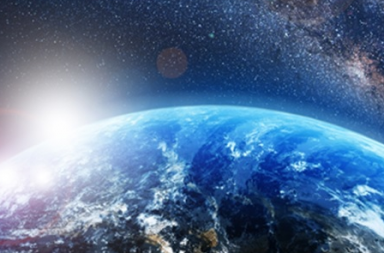 View of planet Earth from space with the sun rising on the horizon and the Milky Way galaxy in the background, representing the global perspective of the independent lodge.
