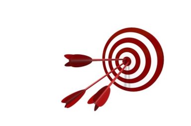 Três setas vermelhas cravadas no centro exato de um alvo circular vermelho e branco, simbolizando a força da concentração.