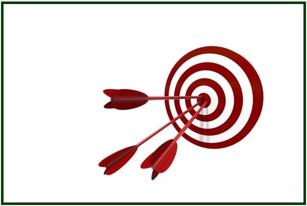 Três setas vermelhas cravadas no centro exato de um alvo circular vermelho e branco, simbolizando a força da concentração.