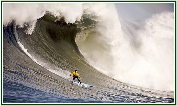 Surfer in a yellow jacket riding a massive big wave at Mavericks representing the science of opportunities and karma.