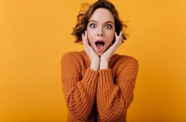 Young woman with a shocked facial expression holding her face, illustrating if talking about theosophy shocks people.